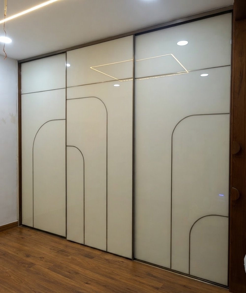 Sliding wardrobe with cream lacquered-glass doors and arched line inlay in Hyderabad